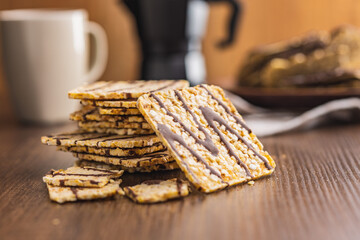 Puffed corn crackers chocolate covered on wooden table.