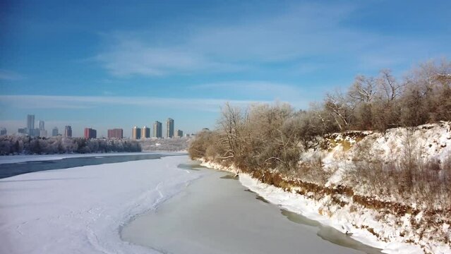 Aerial view of the shore and hiking trail along the frozen North Saskatchewan river in Canada