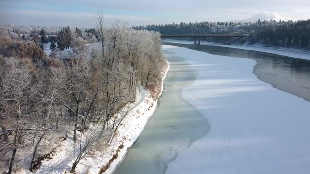 Aerial view of the shore and hiking trail along the frozen North Saskatchewan river in Canada