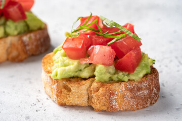 Bruschetta with tomato, mashed avocado and herbs
