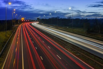 Light trails from fast moving traffic on M42 motorway at night. - obrazy, fototapety, plakaty
