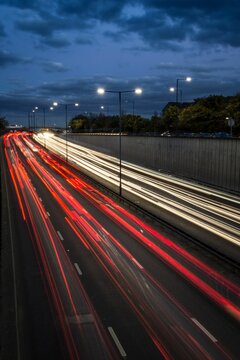 Light trails from speeding cars on the A40 highway in Perivale, London, UK, during the early evening
