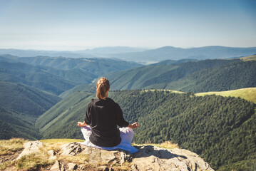 Fototapeta premium Young woman on the top of mountain