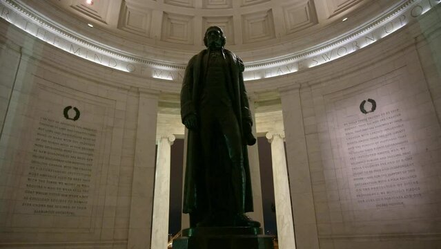 Statue of Thomas Jefferson inside the memorial with writings on the walls
