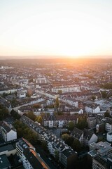 Obraz premium A vertical shot of a sunset over a large city. It's summer and the sun is shining in Cologne.