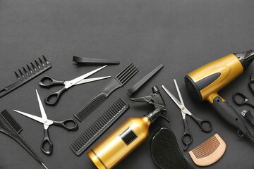 Composition with hairdressing accessories, dryer and spray bottle on black background