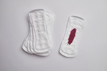 Menstrual pad with red sequins on a pink background. The period of the menstrual cycle, feminine...