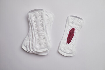 Menstrual pad with red sequins on a pink background. The period of the menstrual cycle, feminine hygiene. Women's health concept

