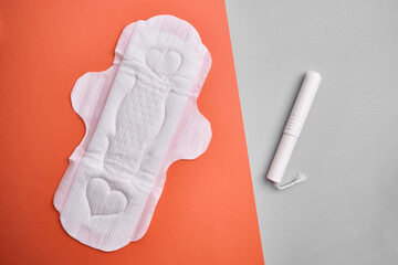 Women's pads and tampon. Sanitary pads lie next to a tampon on an isolated background on a yellow and white background. The concept of health, feminine hygiene and the menstrual cycle
