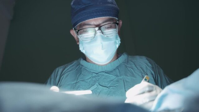 Close up of a doctor doing surgery in the operating room. Slow motion. 