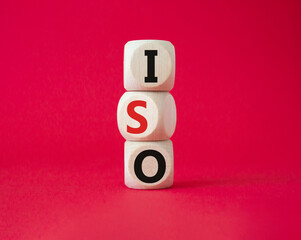 ISO standards quality control symbol. Concept word ISO on wooden cubes. Beautiful red background. Business and ISO concept. Copy space.