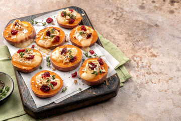Baked Sweet Potato Rounds topped with brie cheese, cranberry and Walnut. Thanksgiving appetizer bites.