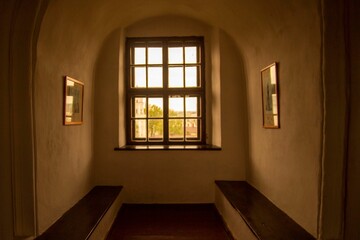 Interior of a cozy room with a window and wooden benches