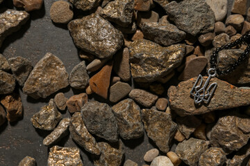 Chain with Ukrainian coat of arms and stones on dark background