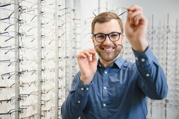 Man evaluating quality of glasses in optical shop