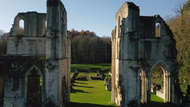 Scenic view of drone flying over ruins of Roche Abbey, fields and woodlands in England on sunny day