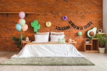 Interior of bedroom decorated for birthday with pinatas, balloons and garland