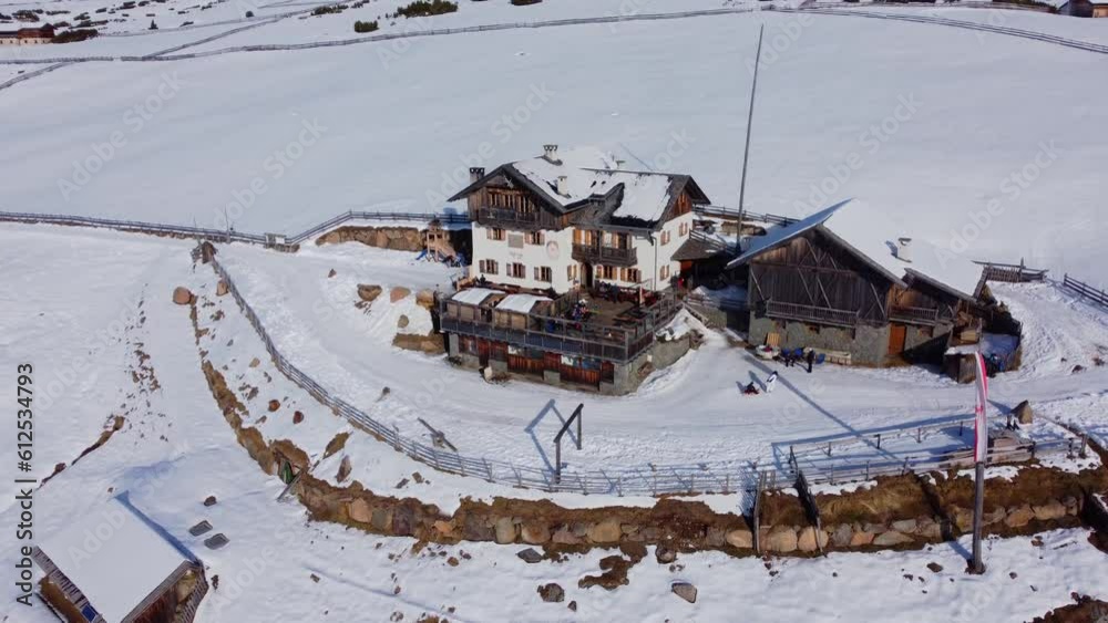 Sticker Drone footage over a winter resort house in a snowy hill