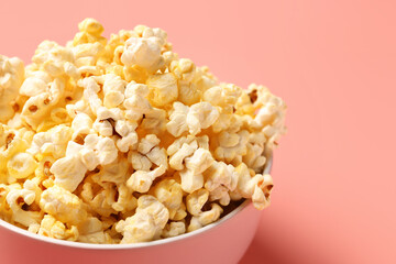 Bowl with crispy popcorn on pink background