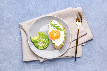 Plate of tasty bruschetta with avocado and egg on grey background