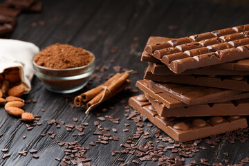 Chocolate with raisins and nuts on a dark wooden background close-up.