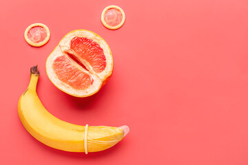 Banana with condoms and grapefruit on red background. Sex concept