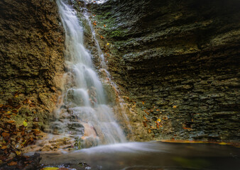 Fototapeta na wymiar A small waterfall in rautal close to jena in thuringia at autumn