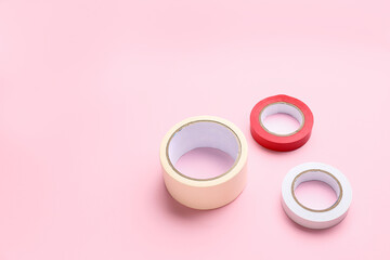 Adhesive tape rolls on pink background