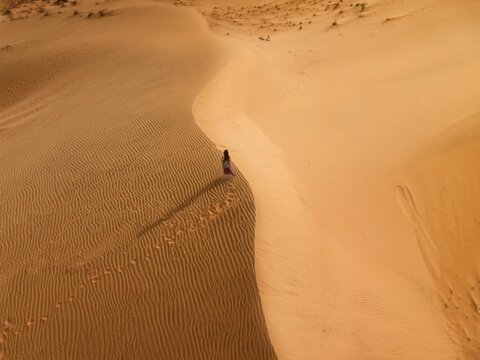 Aerial view of a person walking in the desert