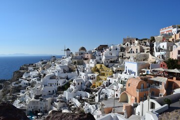 Fototapeta na wymiar Aerial view of the white buildings of Santorini island in Greece overlooking the Aegean Sea