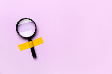 Magnifier with adhesive tape on lilac background