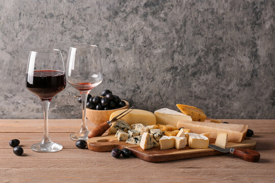 Pieces of tasty cheese and glasses with wine on table