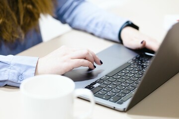 Close up of woman hands working on a laptop