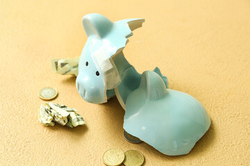 Broken patched piggy bank with money on orange background. Concept of bankruptcy