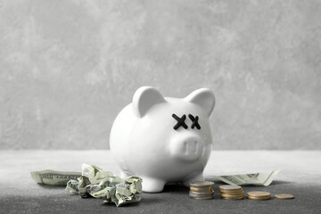 Piggy bank with closed eyes and money on grunge background. Concept of bankruptcy