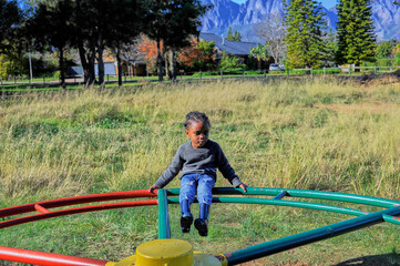 black child playing on a swing