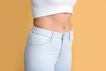 Young slim woman on beige background. Diet concept