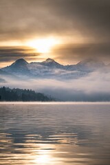 Obraz premium Vertical shot of a seascape under the clouds and the sun