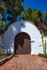 Beautiful White Adobe Arch with Dark Wooden Doors Is Framed by Southwestern Landscaping at the Mission Basilica San Diego de Alcala in San Diego, California, USA