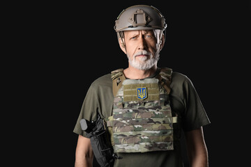 Ukrainian soldier with armor on dark background