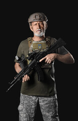 Ukrainian soldier with assault rifle on dark background