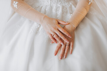 the bride in a white wedding dress. happy beautiful young woman in white traditional wedding dress. Bride's hands close-up