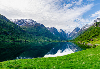 Naklejka na ściany i meble Beautiful view of Norwegian mountains on a clear sunny day with river full of fish. Super green scenery idyllic nature just like a postcard.