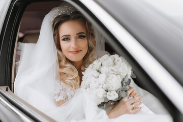 white-haired bride jewelry head sitting in a black car on your wedding day with a bouquet. Portrait of the bride. lush white lace dress