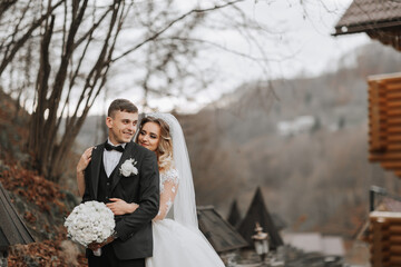 portrait of a young couple of the bride and groom on their wedding day in nature. the bride hugs...