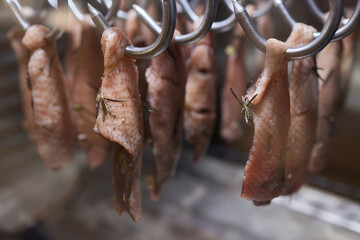 Close up of a smoked meat and belly or beech meat with dark crust in the smokehouse or smoker, food...