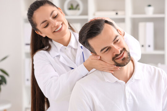 Female physiotherapist working with young man in rehabilitation center, closeup