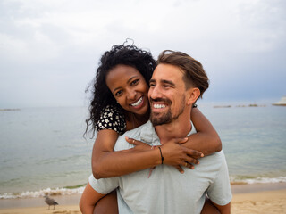 Multiethnic heterosexual couple in love on the beach. Honeymoon, couple having fun