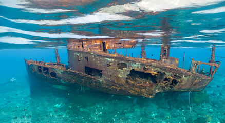 destroyed ship under the deep sea on the dirty sand by day and good lighting - obrazy, fototapety, plakaty
