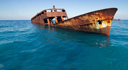 wrecked and rusty ship floating in the sea